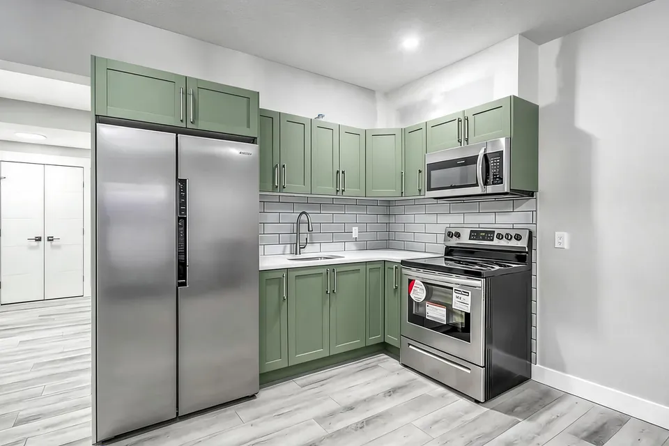 RenderVibe sage-green kitchen cabinet concept with framed doors and stainless steel appliances